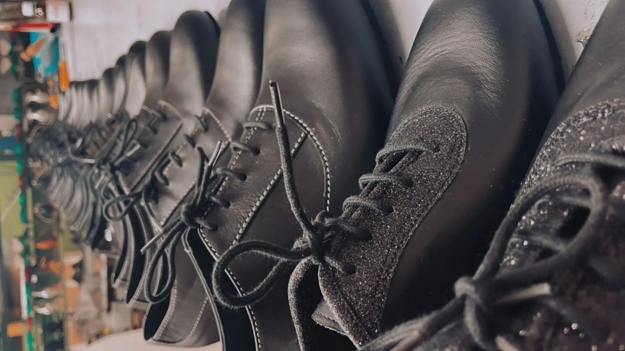 Assortimento calzature su misura: tomaia nera, suole in cuoio e tacchi H2.5 coordinati pronti per finitura e imballo.