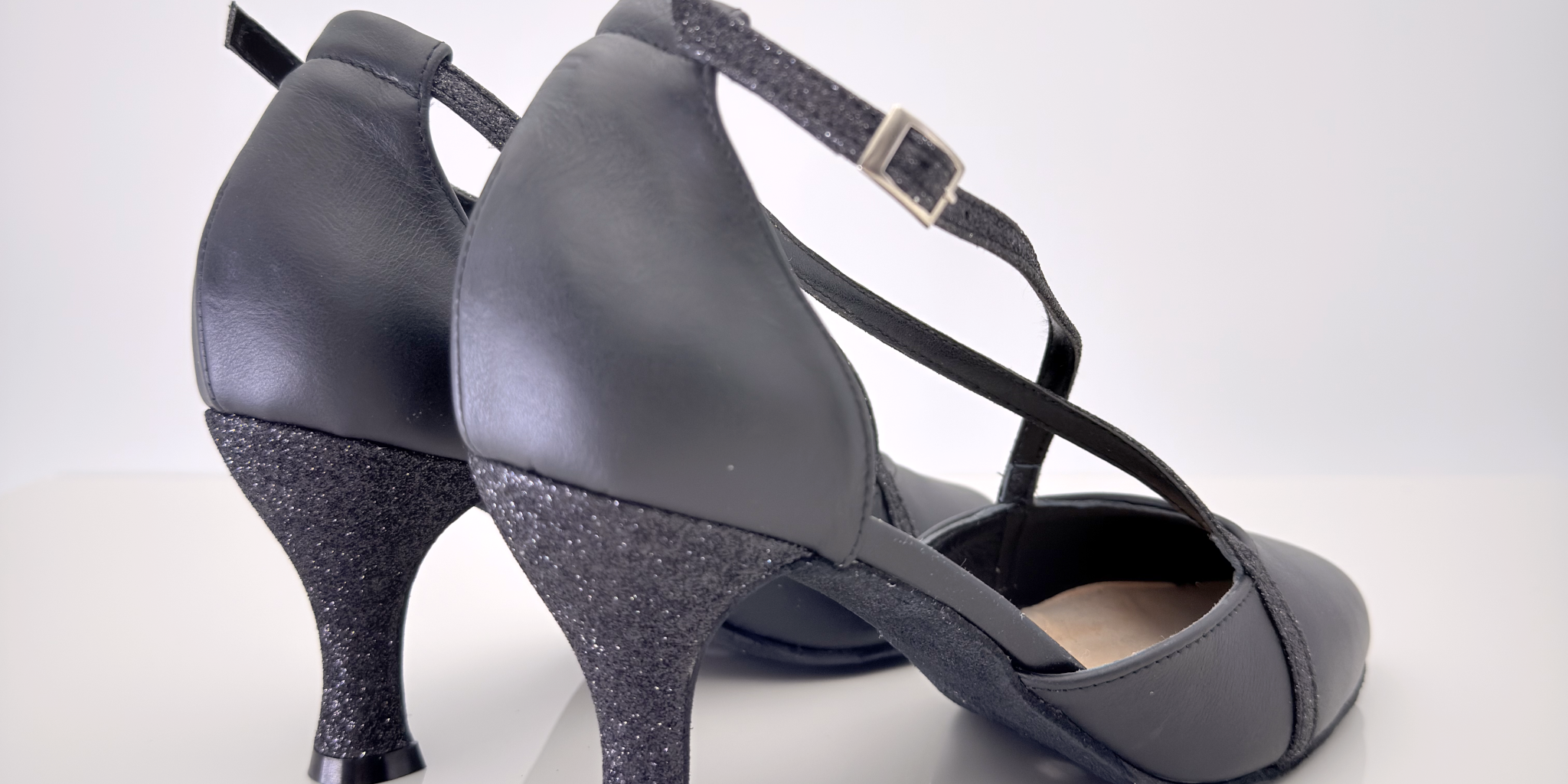 Camila art. 159 Nicole Rimini vista laterale, tomaia in pelle nera e glitter fine nero, cinturino incrociato Mod. 1CAI con fibbia regolabile, tacco rocchetto 7 centimetri, suola bufala, scarpa ballo liscio folk romagnolo artigianale italiana made in Italy
