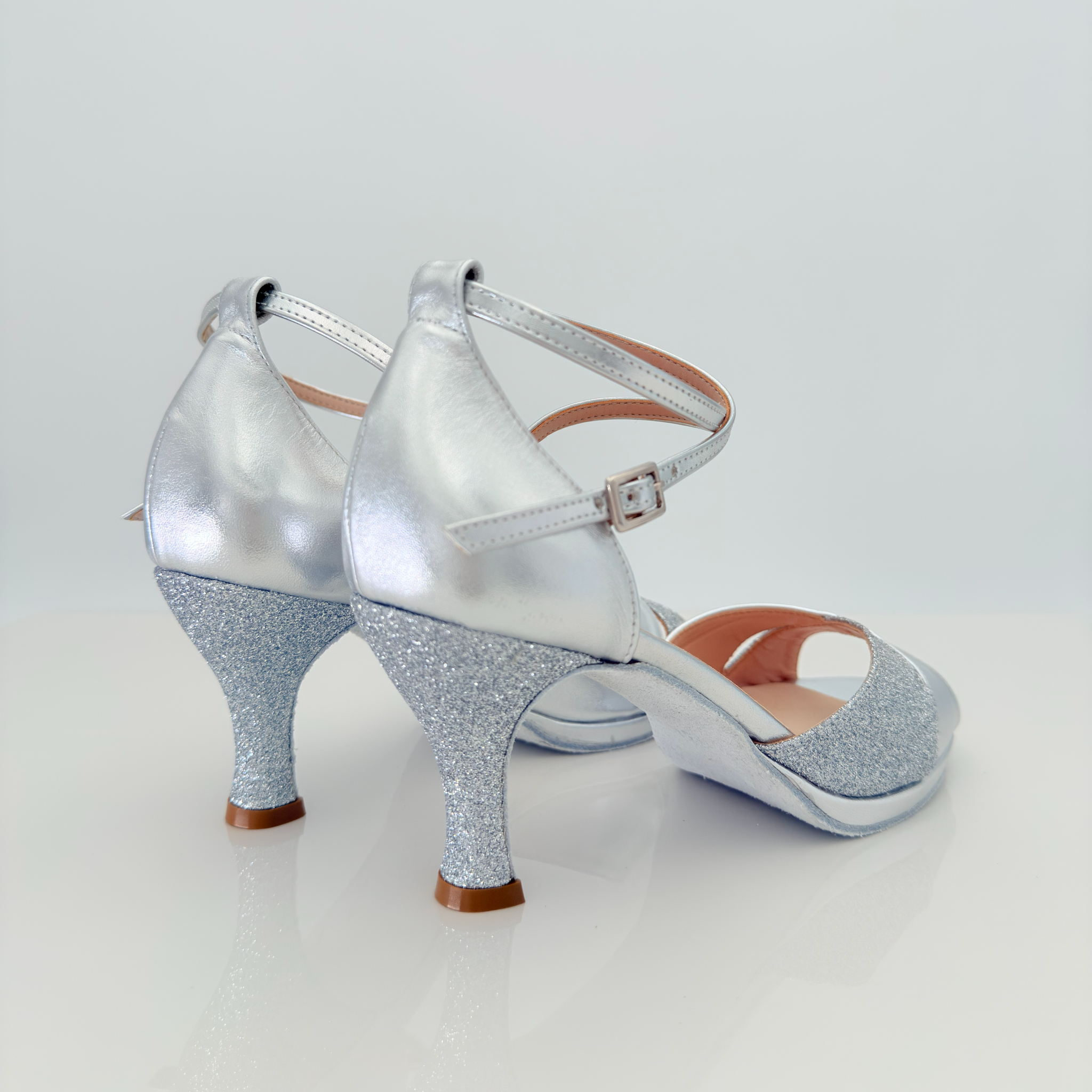 Elisa art. 117 Nicole Rimini vista laterale, pelle laminata argento e glitter fine argento, cinturino incrociato 2CAI, tacco rocchetto 7 cm, plateau 1 cm, tomaia fascia a farfalla avvolgente per pianta larga, scarpe liscio folk romagnolo artigianali italiane
