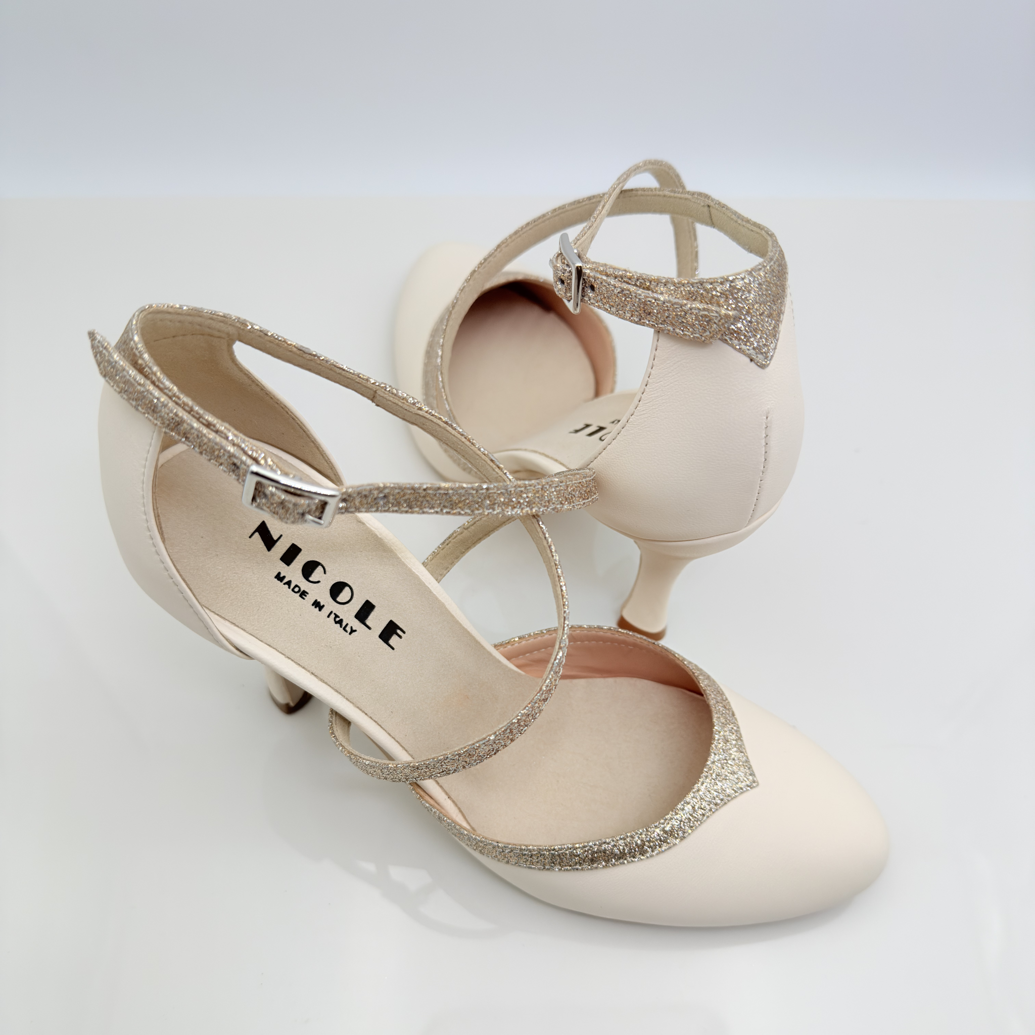 Dettaglio tomaia Marisol art. 206 punta chiusa scollo arrotondato F5P3 cinturino incrociato 1CAI pelle panna tessuto glitter fine nude tacco rocchetto 9HR Nicole Rimini made in Italy
