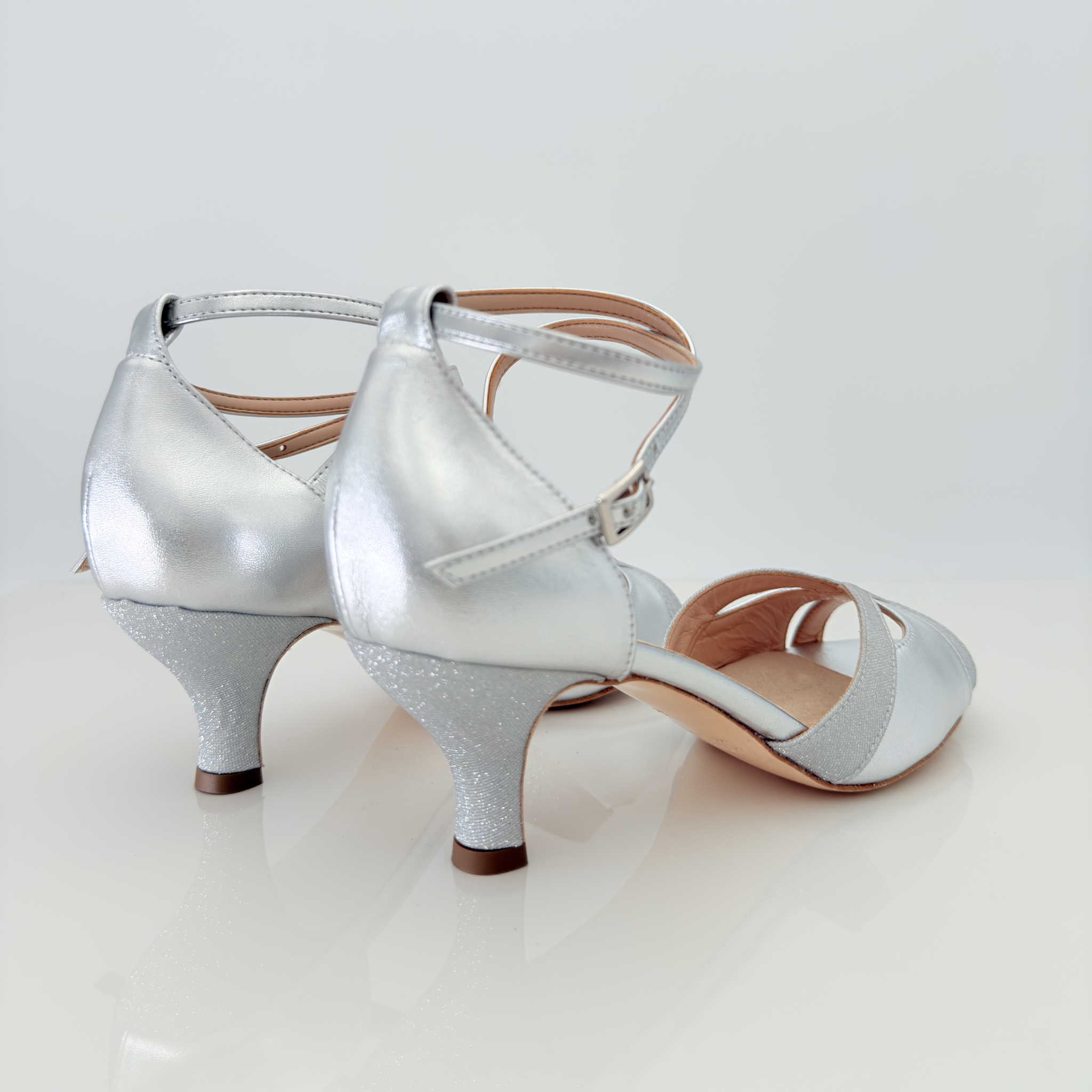 Vista posteriore Mary art. 166 Nicole Rimini tacco rocchetto 5HR pelle laminata argento microglitter punta aperta semi-arrotondata F1P1 cinturino incrociato caviglia 2CAI senza plateau scarpe ballo liscio folk romagnolo made in Italy

