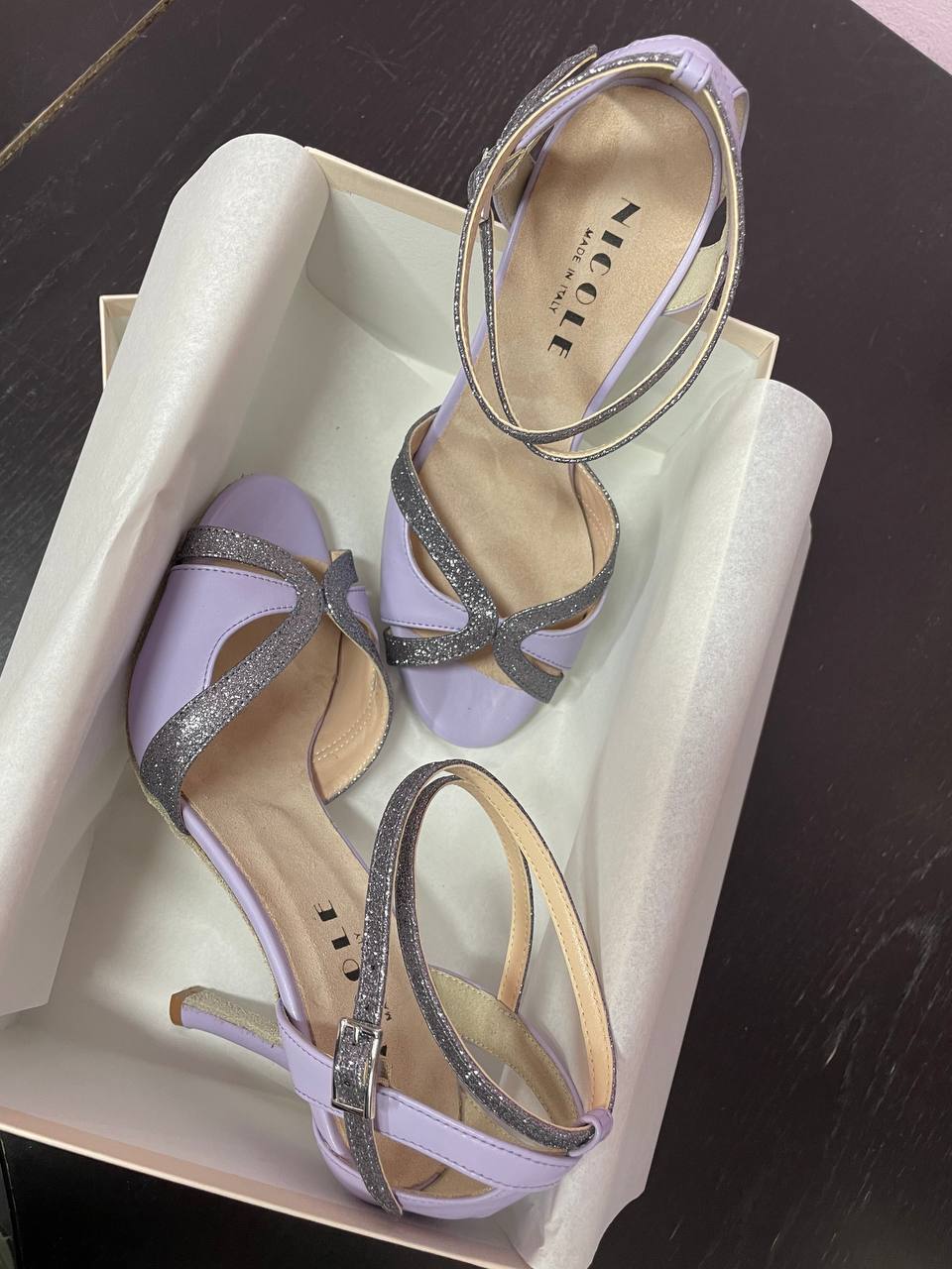 Dettaglio unboxing: scarpe da liscio personalizzate con cinturino a incrocio a fianco del pacco.