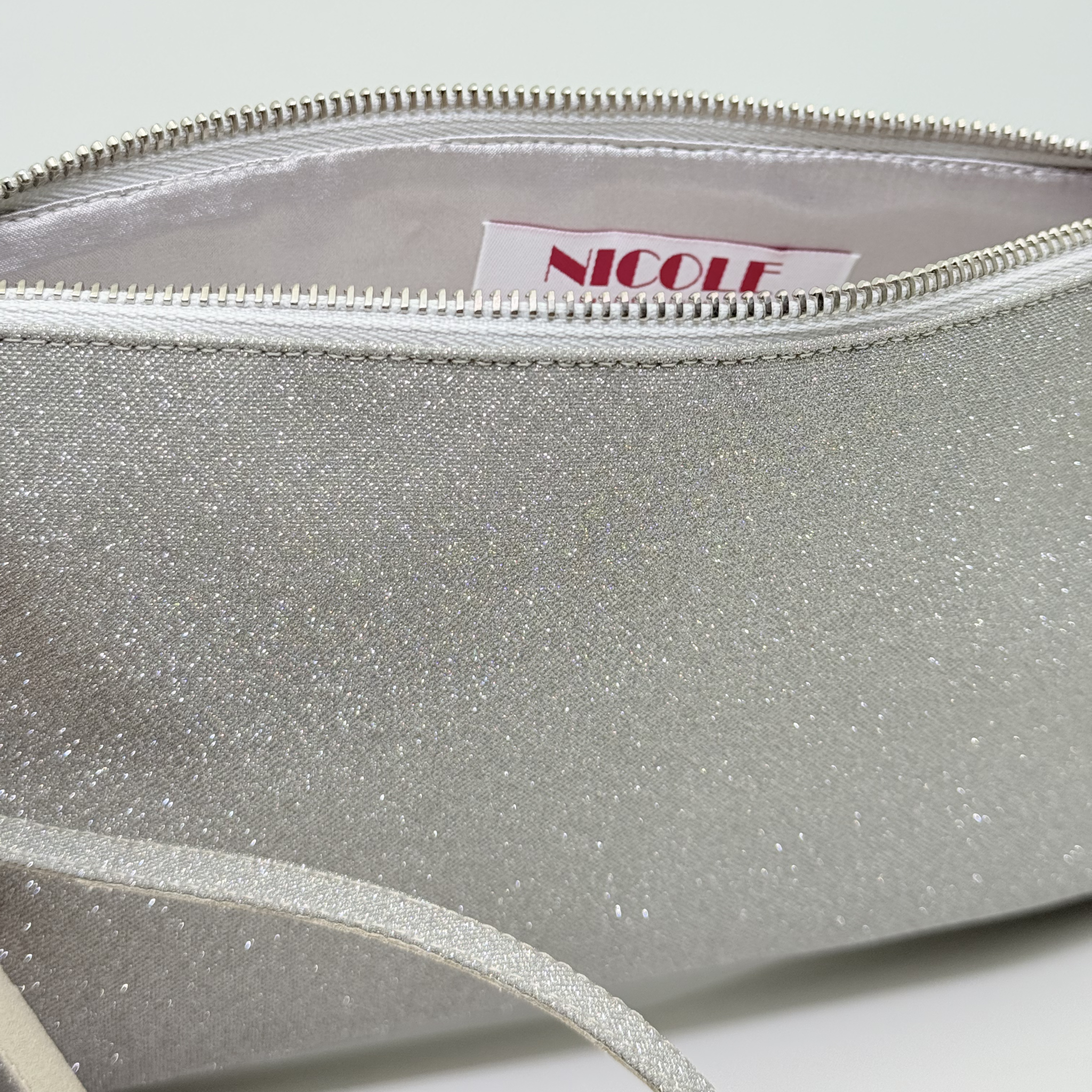Dettaglio interno fodera raso Pochette Microglitter Platino Nicole Rimini — borsa elegante da sera zip resistente braccialetto polso tessuto microglitter durevole accessori cerimonia made in Italy
