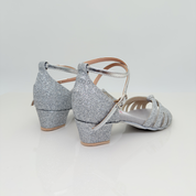 Sole art. 401G Nicole Rimini vista laterale, tessuto glitter argento brillante, cinturino incrociato caviglia 2CAI, tacco rocchetto 3,5 cm quadrato plateau 1cm, fascia a gabbia tomaia bambina, scarpe da ballo folk liscio romagnolo kids girl artigianali italiane

