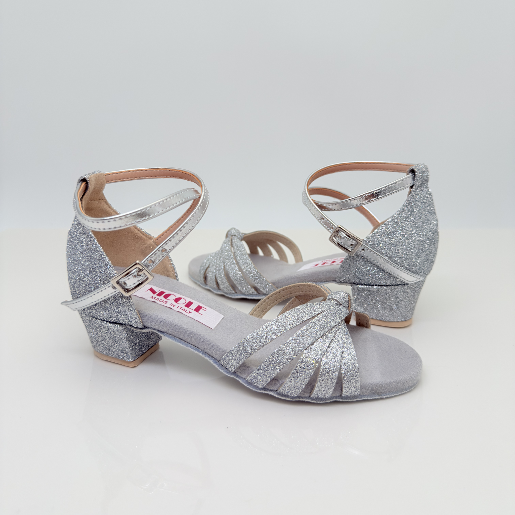 Dettaglio cinturino incrociato alla caviglia Mod. 2CAI Sole art. 401G Nicole Rimini, fascia a gabbia in tessuto glitter argento con più listini, fibbia regolabile laterale, scarpe da ballo folk liscio romagnolo bambina kids girl
