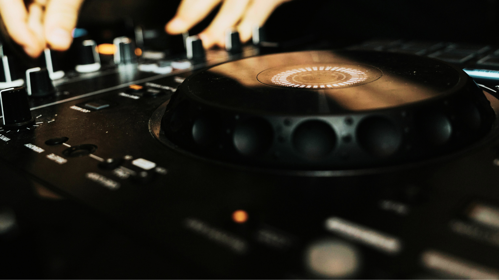 Primo piano dettagliato di un mixer Pioneer DJM-A9 professionale con fader e manopole EQ illuminate, azionato da mani esperte.